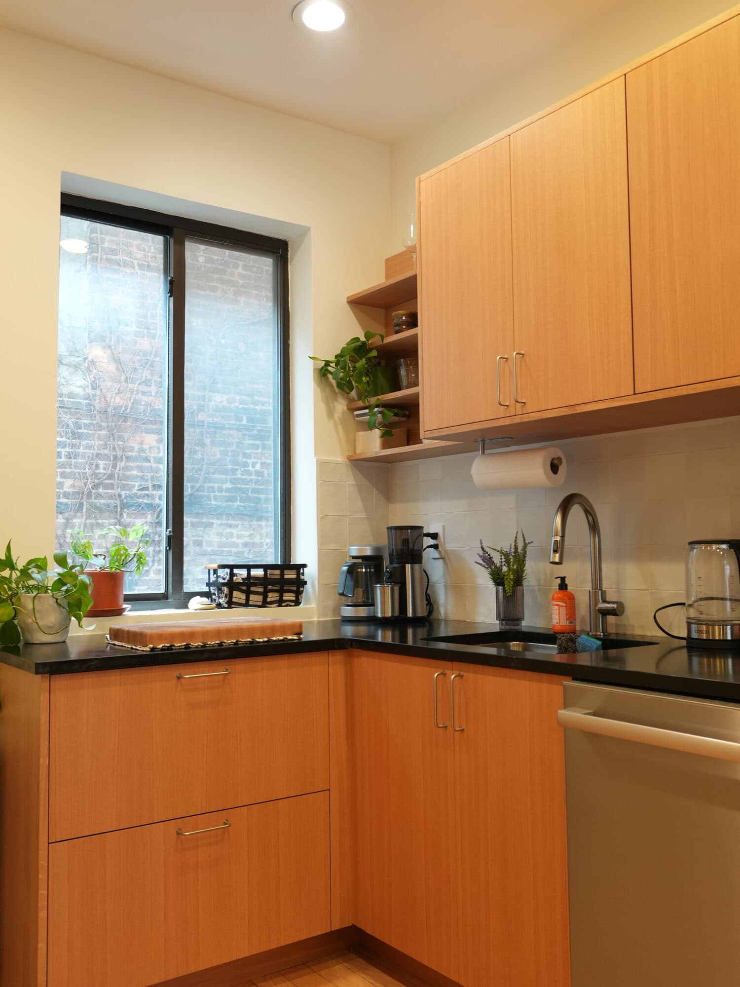 Greenpoint kitchen renovation by Alpha — oak cabinetry and window over the counter