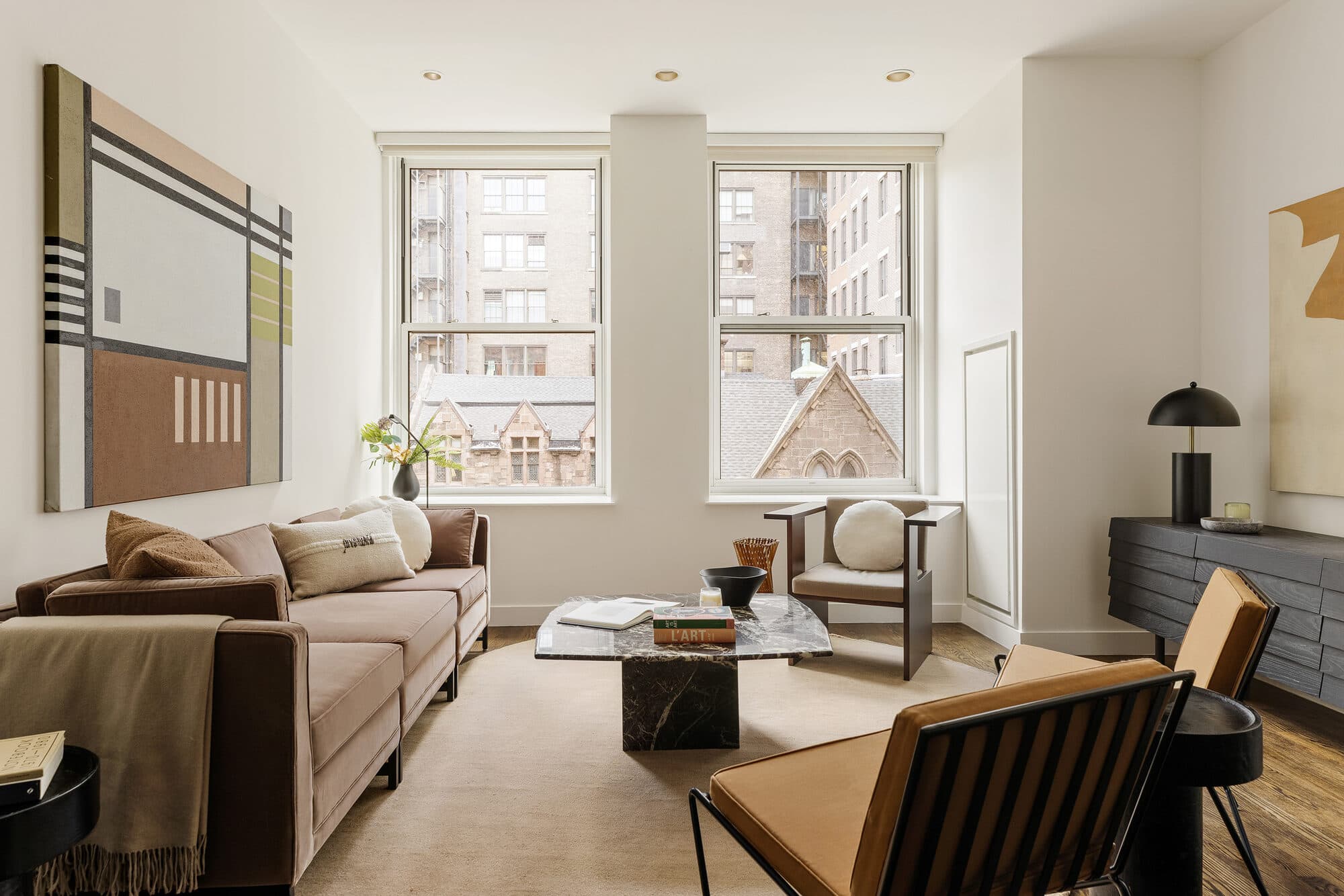 Living room with large windows and neutral finishes after the renovation