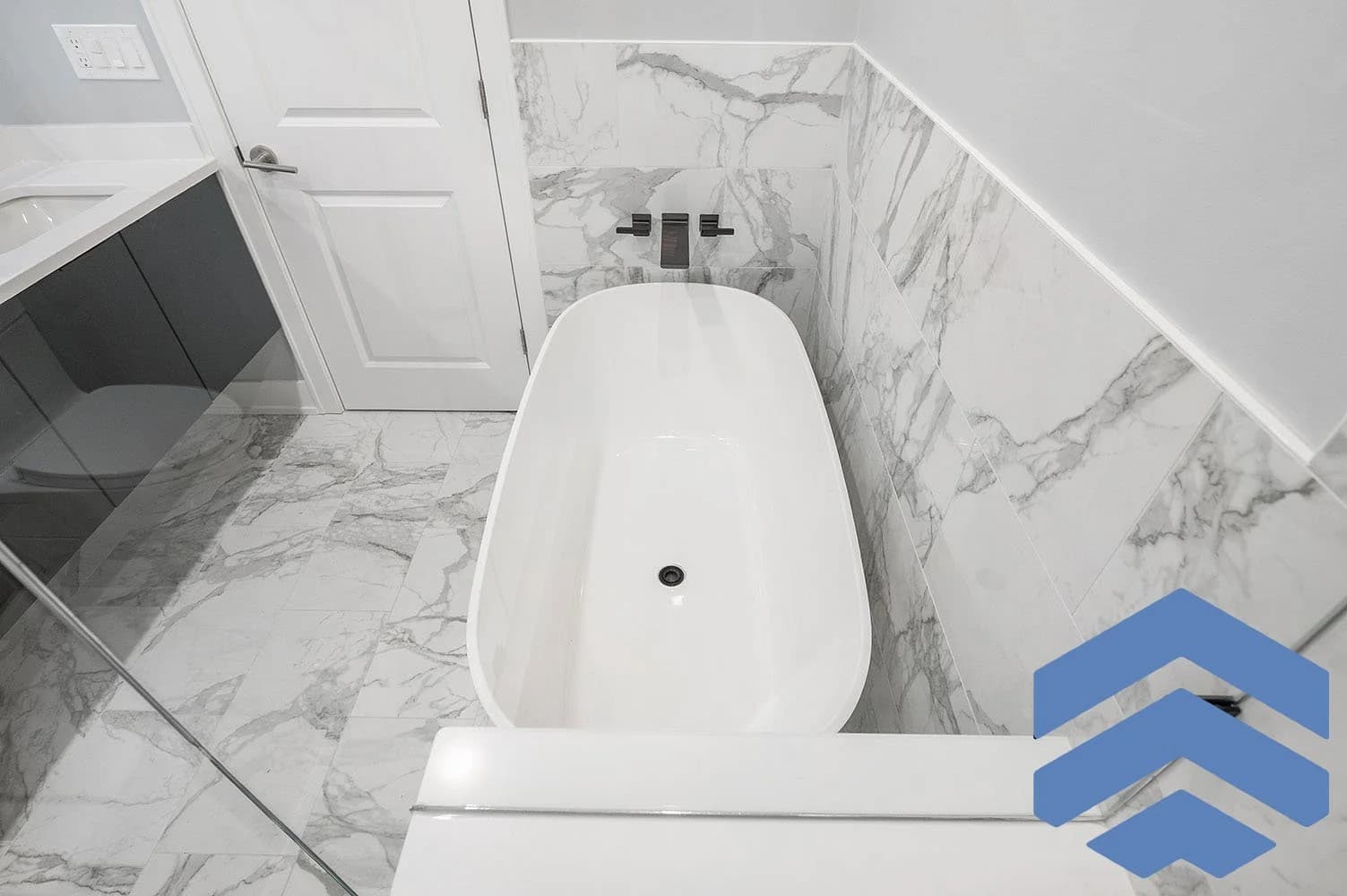 Bathroom renovation with bright marble-inspired wall and floor finishes